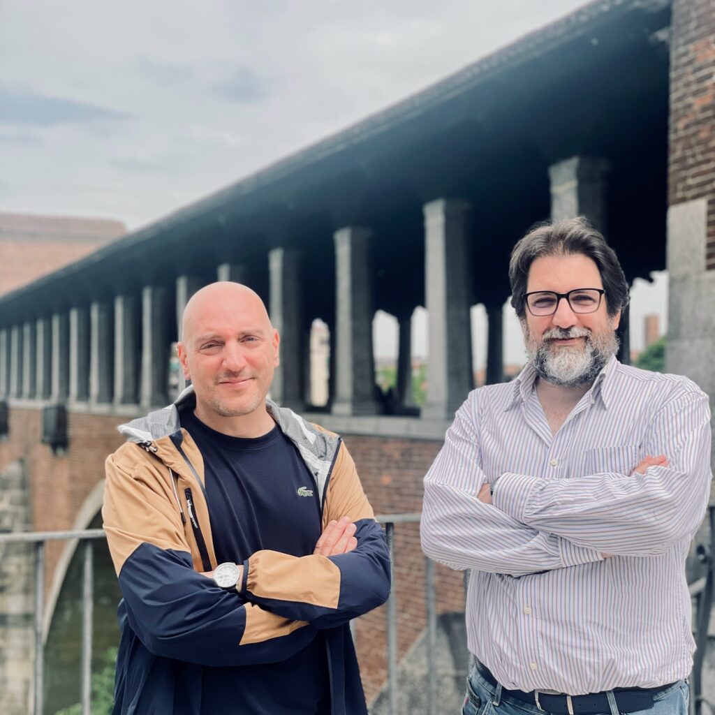 Pietro Pace e Mauro Vanetti sullo sfondo il ponte coperto di Pavia